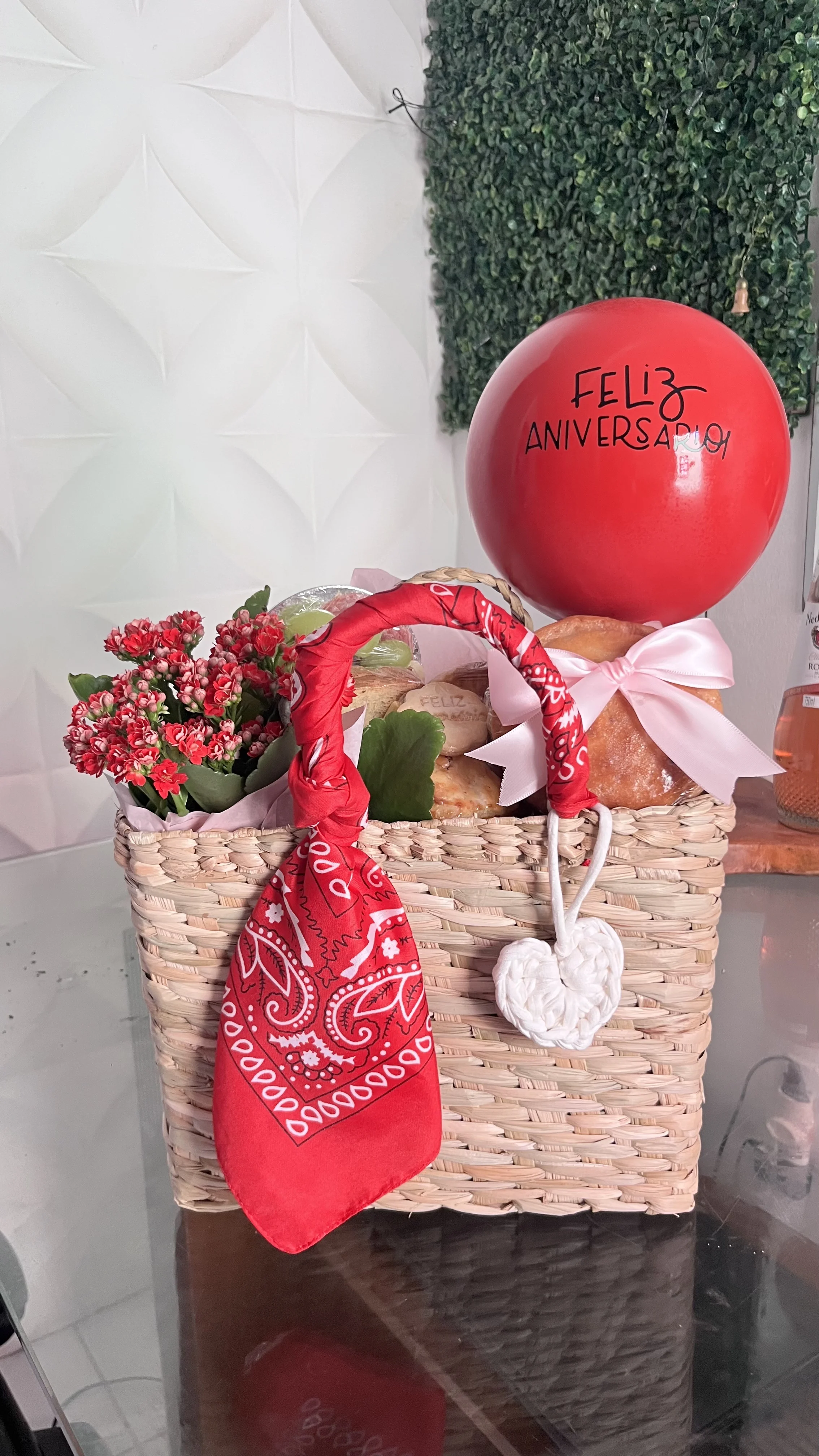 Caixa com frutas, flores, biscoitos e doces em composição delicada.